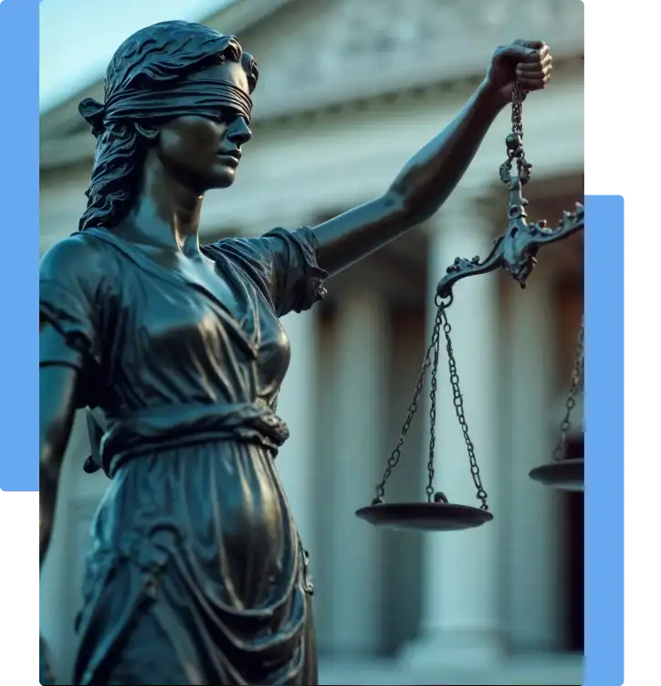 Statue of Lady Justice blindfolded and holding scales, standing in front of a courthouse
