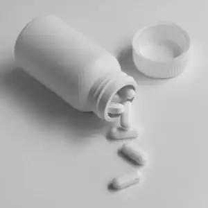 White pill bottle with tablets spilled out, depicting dangerous or defective pharmaceutical drugs