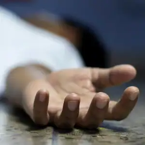 Lifeless hand on the floor after a fatal car or truck accident, symbolizing sudden loss.