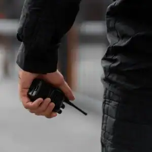 Close-up of law enforcement officer holding a radio during a police action