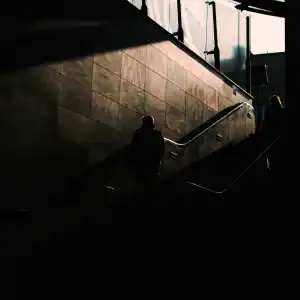 Dimly lit stairwell with silhouettes, highlighting poor visibility risks