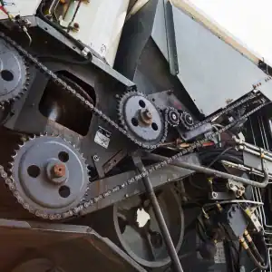 Close-up of industrial equipment with exposed gears and chains, representing mechanical failure