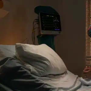 Empty hospital bed with a turned-off heart monitor, representing a death due to medical malpractice.