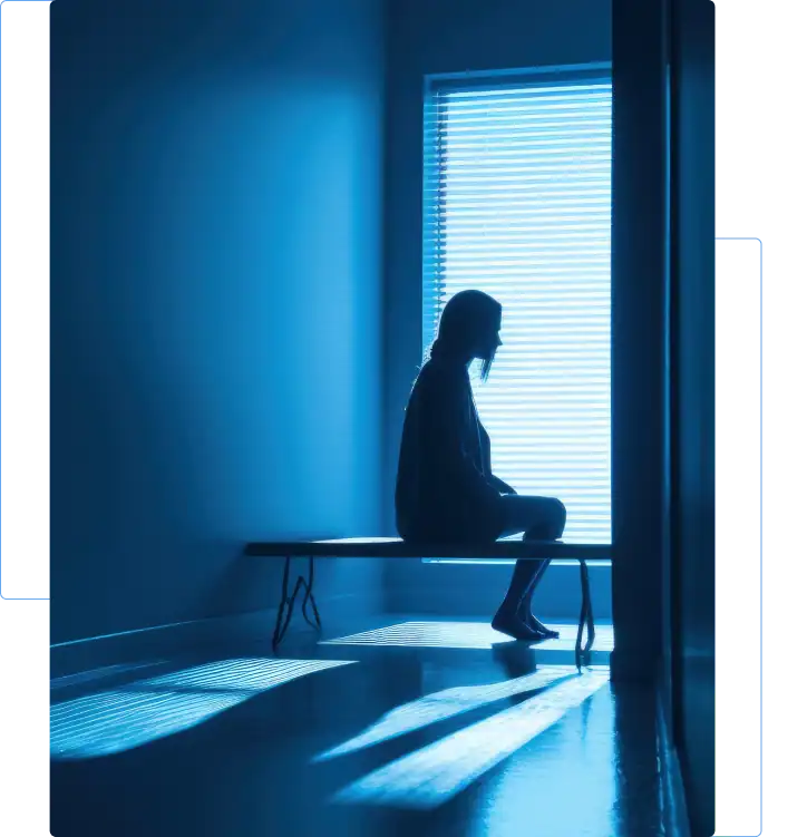 Woman sitting alone in a dim room, reflecting emotional trauma after a motor vehicle accident