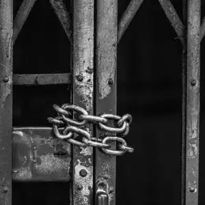 Prison gate locked with heavy chains, representing incarceration or jail-related death