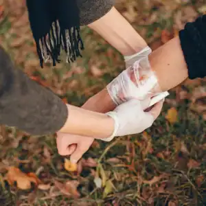 Person receiving first aid for a severe arm injury after a bicycle or scooter accident