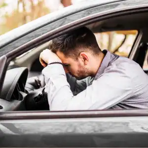 TLC Driver accident Frustrated driver with head resting on steering wheel after a stressful accident involving an uninsured or underinsured motorist