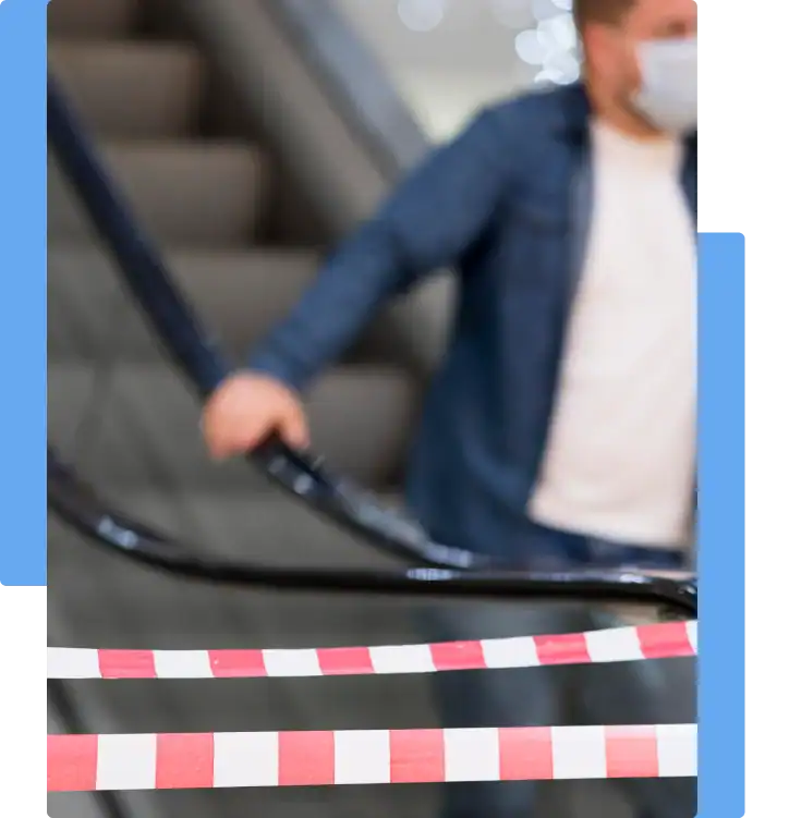 Slip and fall lawyer: Escalator blocked with warning tape, with a masked man in the background — representing unsafe premises and fall risk