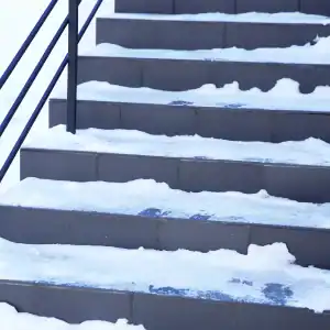Snow-covered stairs posing slip and fall risk during winter