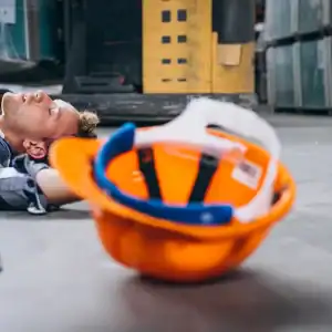 Injured construction worker lying on site floor after a work accident