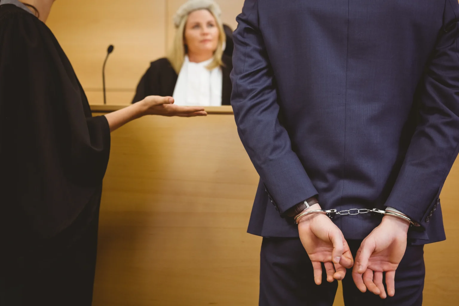 Wrongful Conviction: judge talking with criminal handcuffs