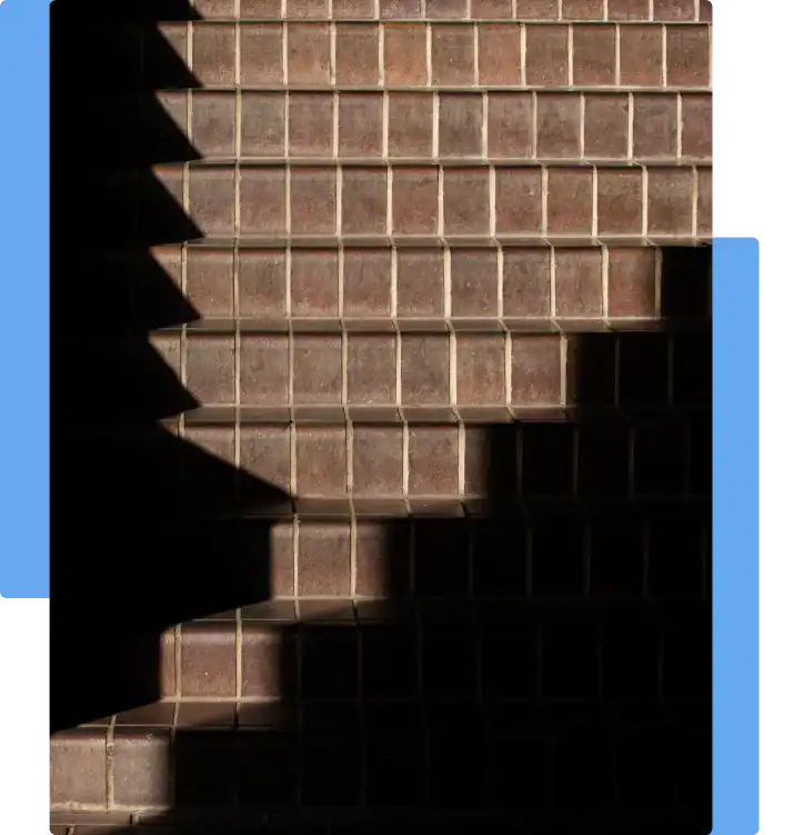 Dimly lit tiled staircase with deep shadows, illustrating a potential slip and fall hazard due to poor lighting
